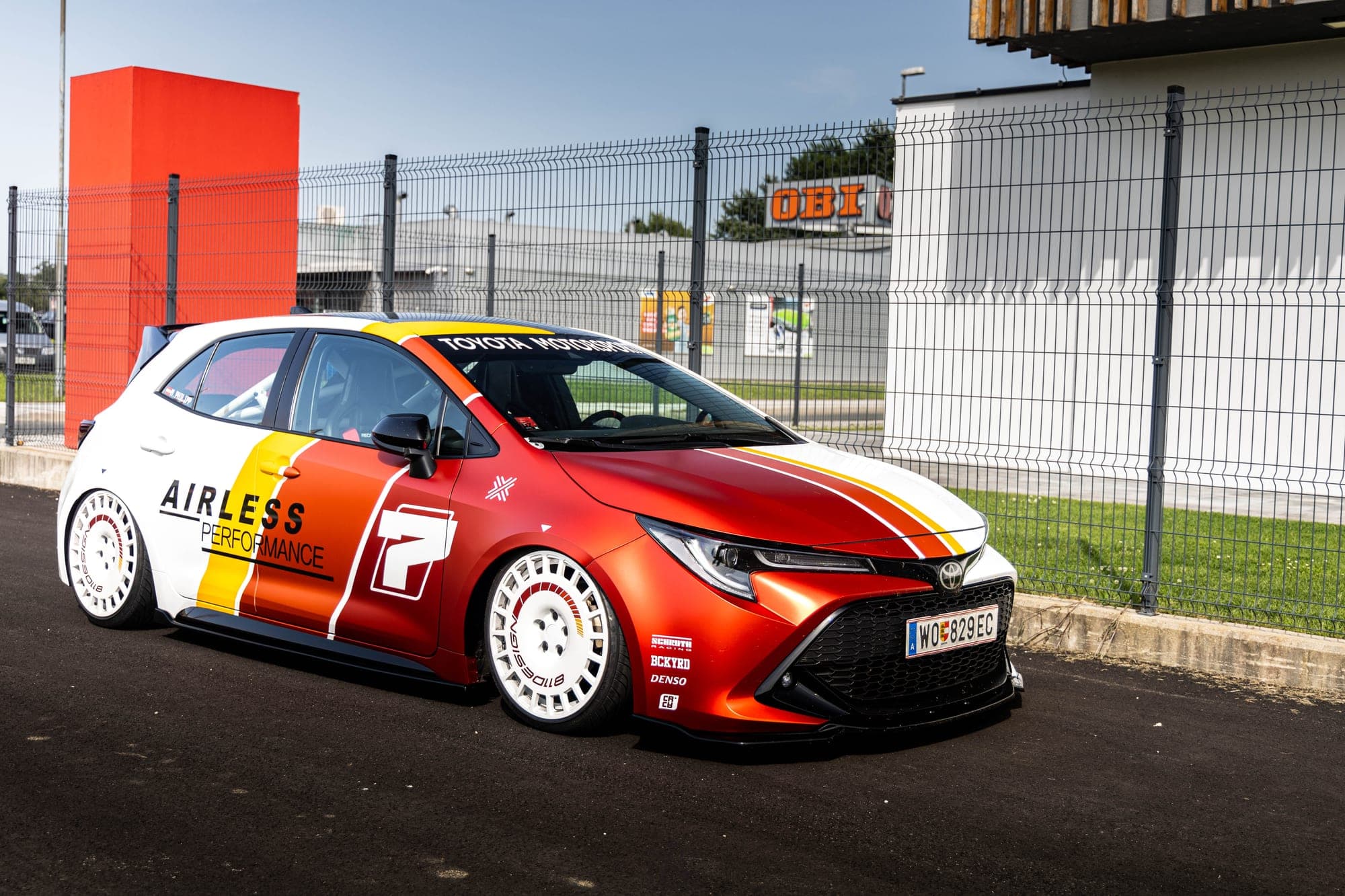 Toyota Corolla z rdeče-oranžno livrejo, posneta od spredaj