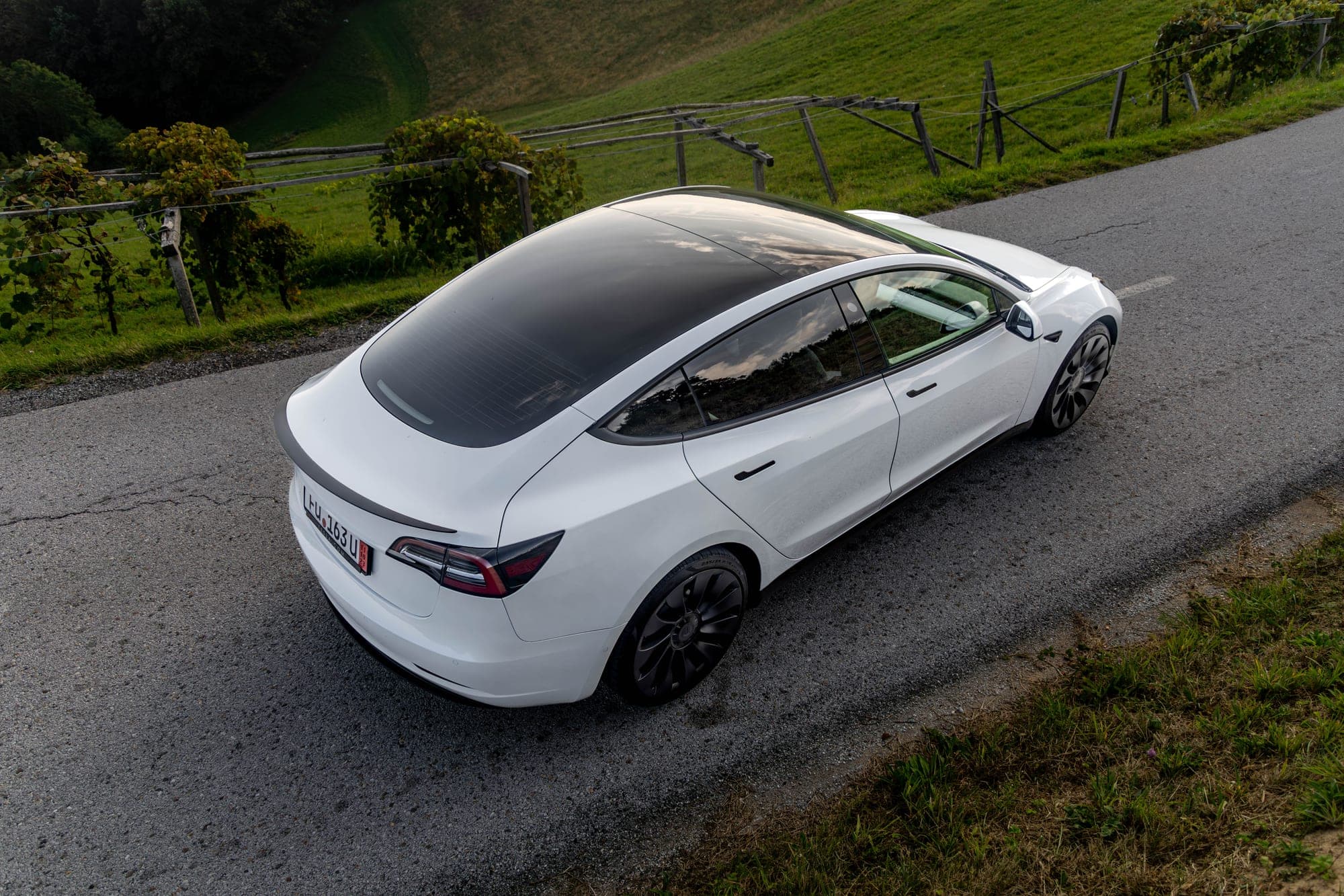 Bela Tesla Model 3 na ovinkasti podeželski cesti
