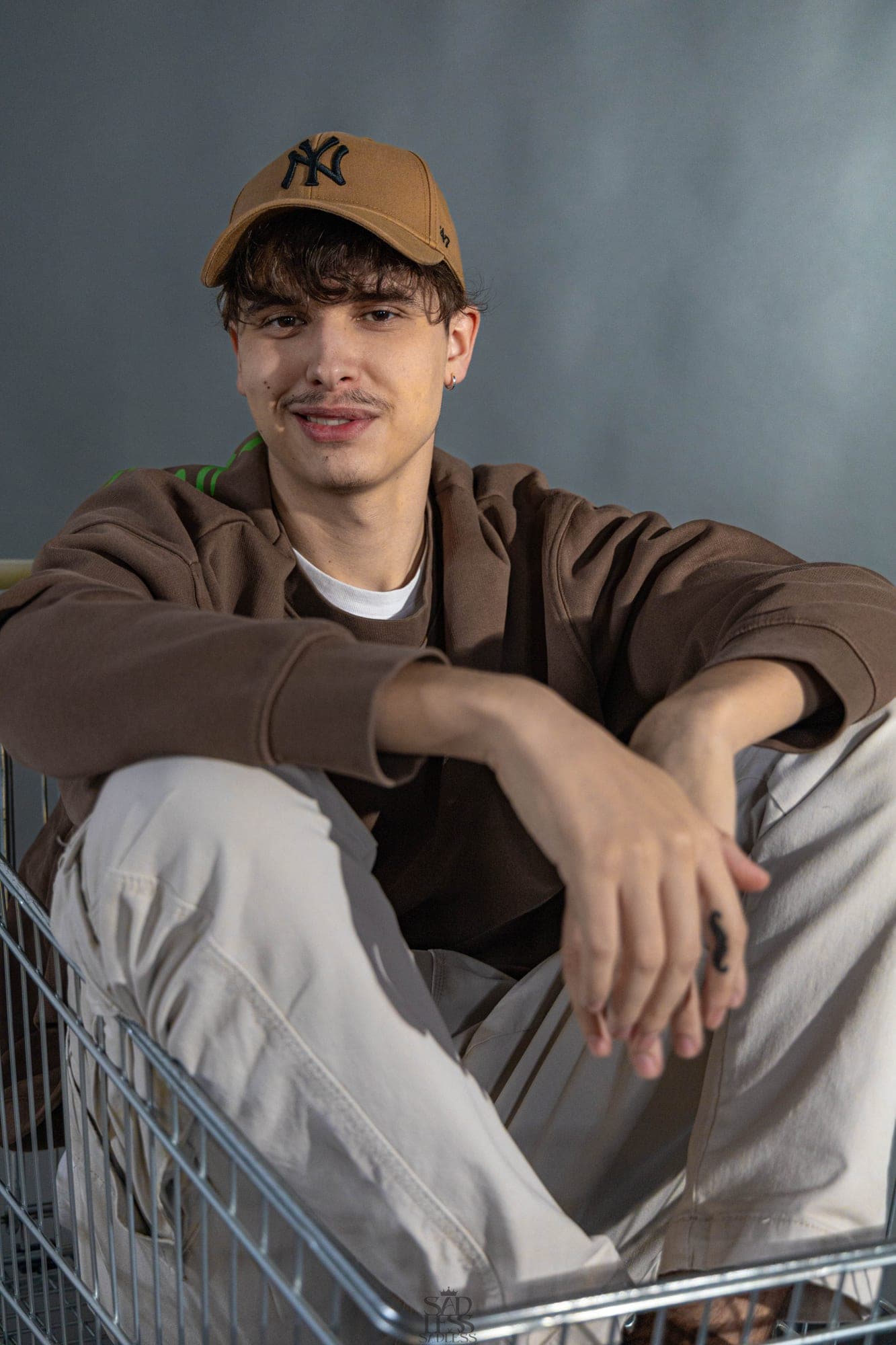 Konceptualni studijski portret izvajalca v nakupovalnem vozičku