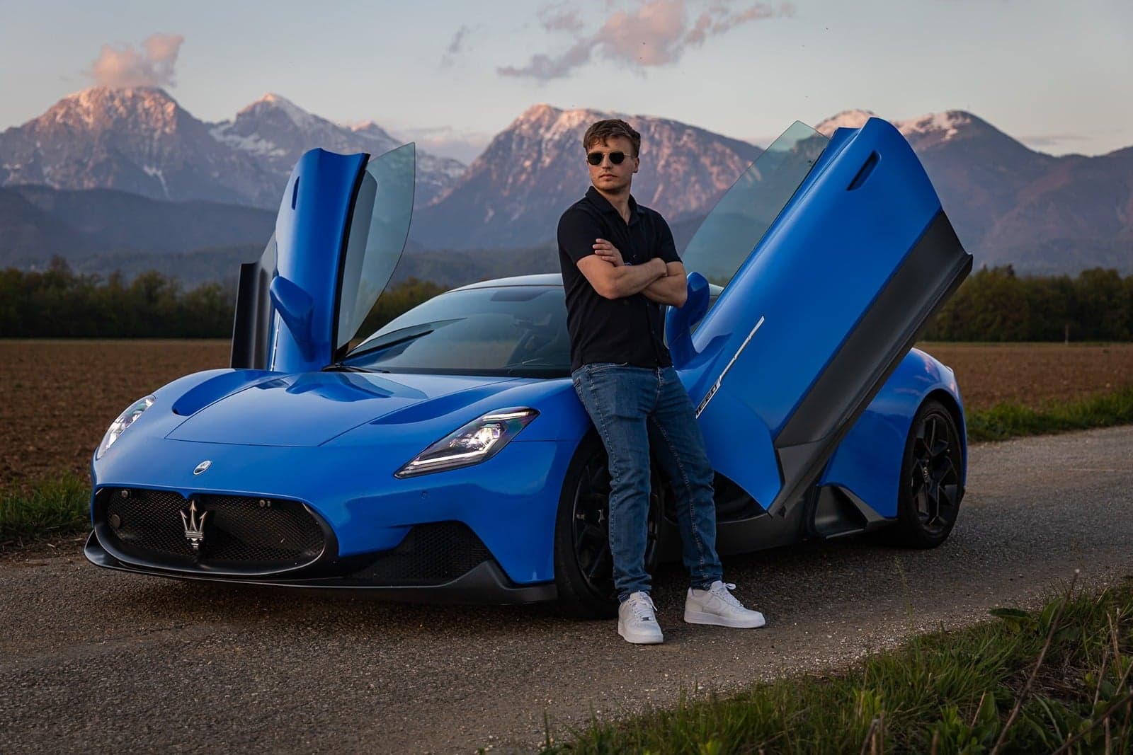 Mihael Klevže ob modrem Maseratiju MC20 pred Kamniško-Savinjskimi Alpami