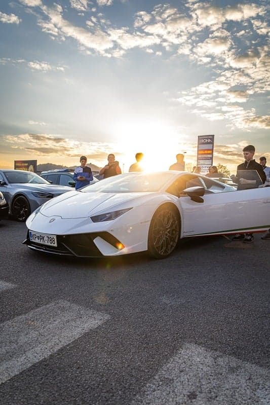 Bel Lamborghini Huracán proti sončnemu zahodu na dogodku Vozi Sanje